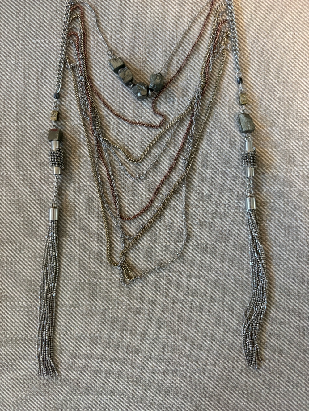 multi-strand mixed metal layered chain necklace featuring delicate beaded tassel